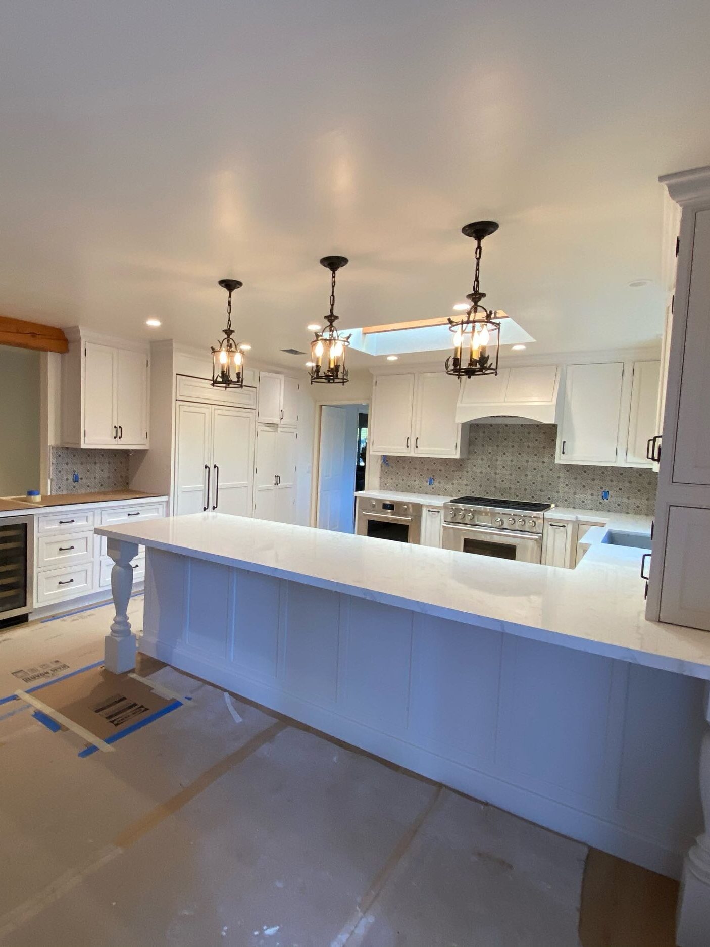 Three chandeliers hanging above a newly refurbished kitchen. 